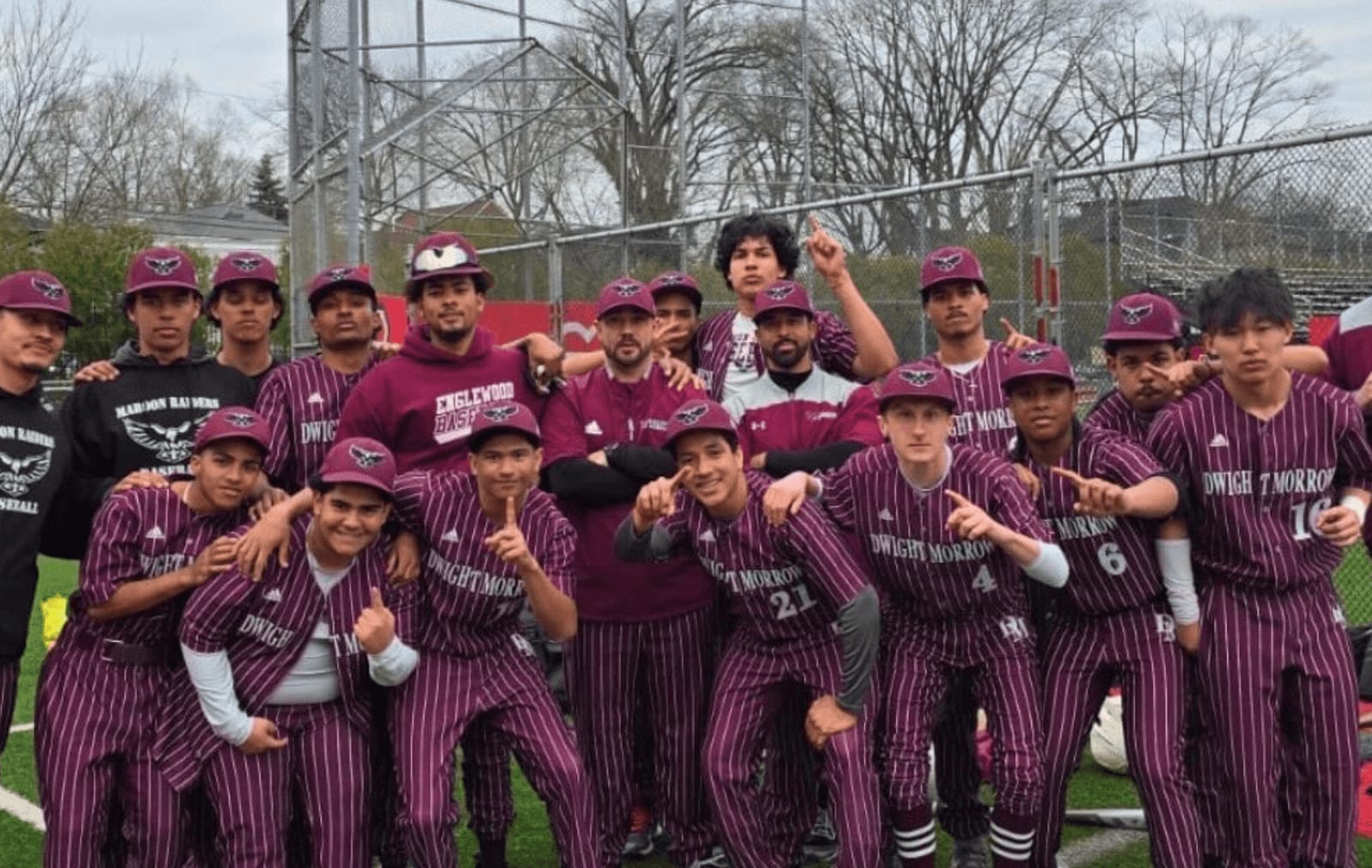 A high-school baseball team in maroon pinstripes posing on the field, with Cooper Won at the far right